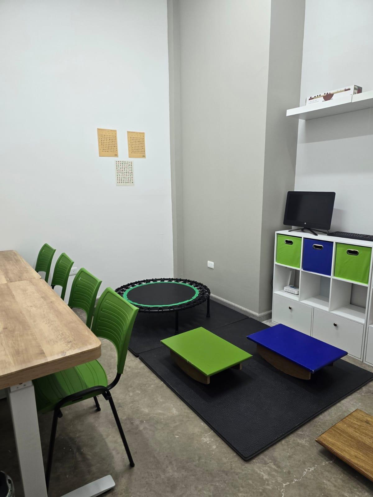 Sala de terapias y entrenamientos con trampolín, tablas de equilibrio y estación de trabajo